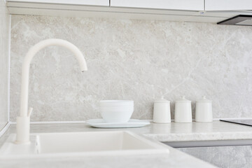 Designer kitchen sink with water white tap or faucet at home bright interior.