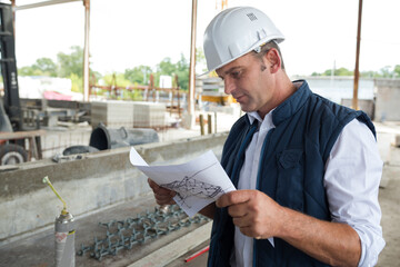male worker on site looking at plans