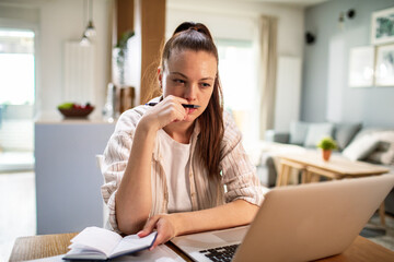 Focused woman working on laptop at home