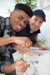 the carpenter is assembling the kitchen and works with screwdriver