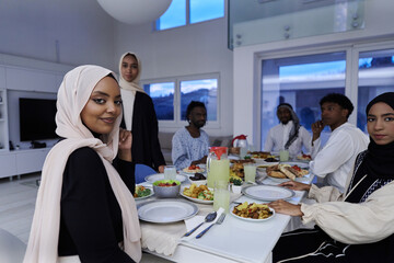 In the sacred month of Ramadan, a Muslim family joyously comes together around a table, eagerly awaiting the communal iftar, engaging in the preparation of a shared meal, and uniting in anticipation