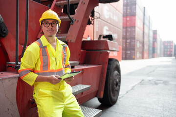 Portrait Asia foreman holding tablet computer with truck and container background