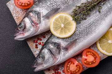 Fresh raw ocean sea bass fish with salt, spices and herbs