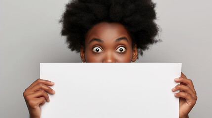 Mulher afro-americana surpresa espiando por trás de um outdoor em branco - obrazy, fototapety, plakaty