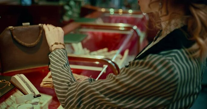 woman trying expensive gold bracelet with brilliants in jewelry store in 19 century, 4K, Prores