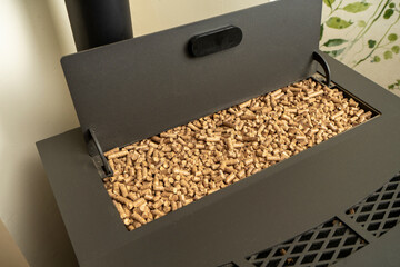 Image of a pellet stove with the hopper filled to the brim with ecological fuel, sustainable and renewable heat.