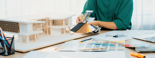 A cropped image of skilled interior designer chooses appropriate floor material for house model...