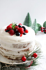 Tradizionale pandoro o panettone natalizio italiano con panna e frutti di bosco su sfondo bianco...