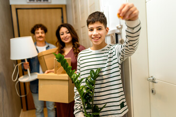 Latino family moving in to new apartment, holding boxes and plants.