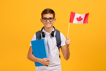International Education. Happy Teen Boy With Backpack Holding Canadian Flag And Workbooks