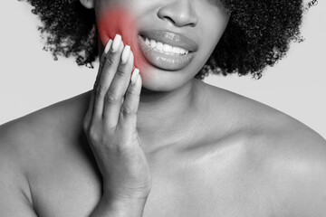 Young woman holding cheek in pain, toothache highlighted in red