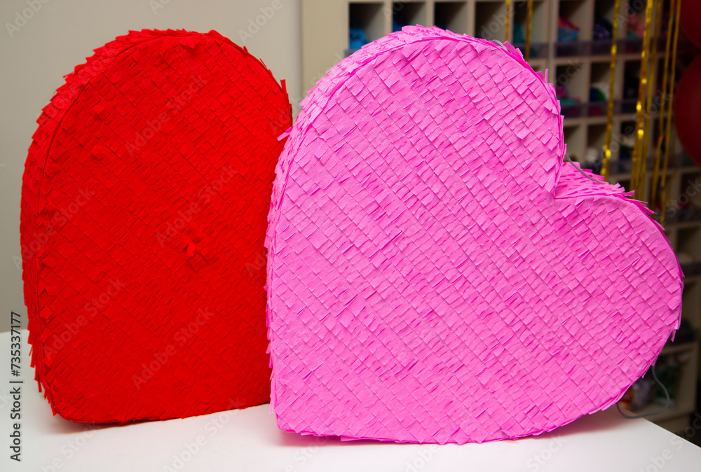 Wall mural red and pink heart on wooden table, heart shaped pinatas