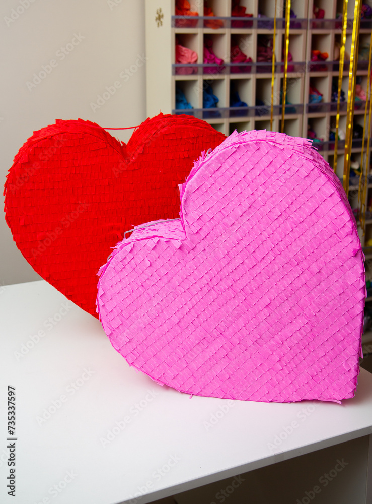 Wall mural red and pink heart on wooden table, heart shaped pinatas