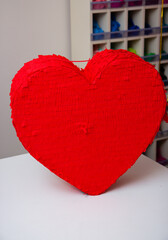 red heart on a wooden background, cardboard piñata game
