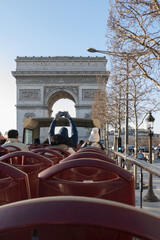 Tourist taking picture of Arc de Triumphe in a tour bus in Paris