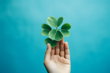 four leaf clover in hand holding a green background