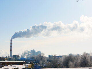 View of a winter city with a smoking chimney.