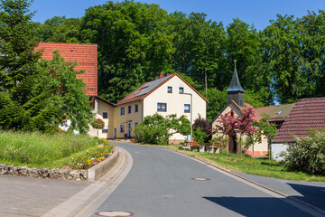 Fototapeta na wymiar Houses, chapel and trees in village Leienfels, district of Pottenstein (Franconian Switzerland), Bavaria, Germany