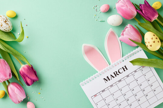 Easter's delicate dance: tulips and traditions. Top view of tulips in, assorted Easter eggs, and playful bunny decorations, calendar on teal backdrop with space for celebratory messages