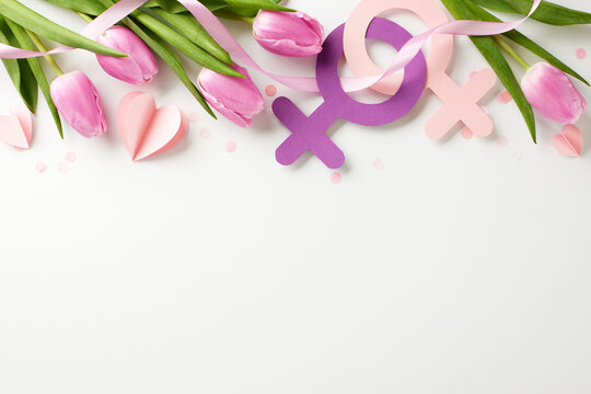 Tales of tenacity: celebrating women's journeys. Top view of tulips, womanhood symbols, and heart shapes on white background with blank space for narratives or commercial use - Powered by Adobe