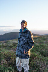 A young man walking through countryside and smiling