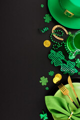 Leprechaun's delight: a spirited table for St. Paddy's merriment. Top view vertical shot of plates, cutlery, green party glasses, confetti, hat, green beer on black background with greeting zone