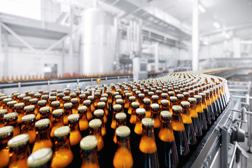 Brewery conveyor on modern alcohol drink production line. Brown glass beer bottles on industry...