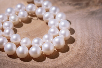 beautiful women's necklace made of natural white sea pearls on a wooden backing close-up view