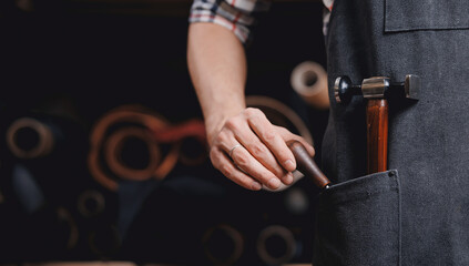 Man shoemaker hold different rolls natural leather brown, working with textile in workshop of...