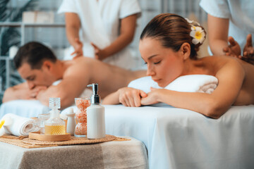 Obraz na płótnie Canvas Caucasian couple customer enjoying relaxing anti-stress spa massage and pampering with beauty skin recreation leisure in day light ambient salon spa at luxury resort or hotel. Quiescent