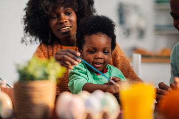 African american family coloring easter eggs on easter. - Powered by Adobe