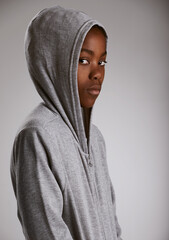 Hoodie, fashion and portrait of teenager in studio with serious kid in stylish streetwear on grey...