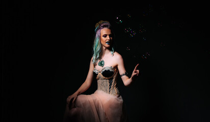 Woman is sitting on chair and blowing bubbles