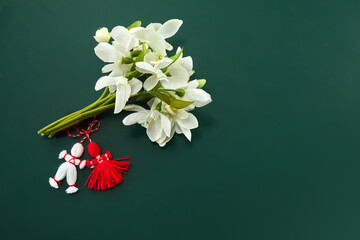 A bouquet of snowdrops flowers and a red-white martenitsa, a symbol of the holiday on March 1,...
