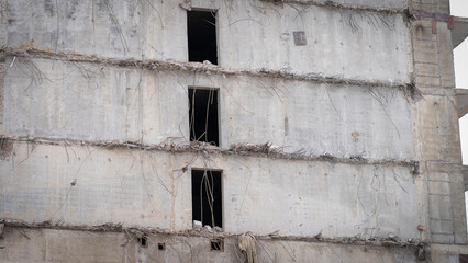 Partially demolished building close-up, bankruptcy of construction firms, deceived equity holders...