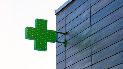Green Cross Sign Pharmacy. Sign of pharmacy on facade of building in residential area.