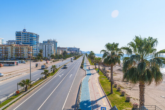 Busy City Highway Road Next to a Blue Sea and Sandy Beach Under The Clear Sky in a Hot Sunny Summer day from a Pedestrian Stone Bridge