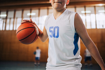 Cropped picture of a junior basketball player in action dribbling a ball.