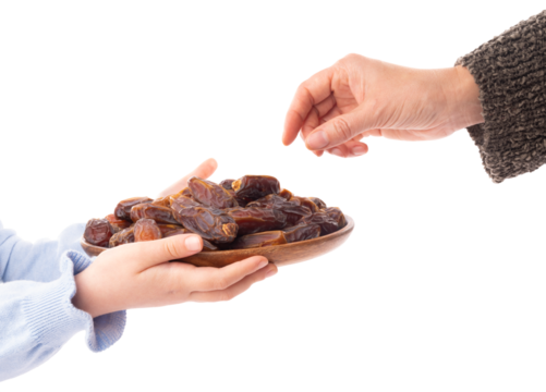 Unrecognizable caucasian child holding full wooden plate of date fruits. Woman hand taking one. Side view isolated white background. Copy space. Islam hold month Ramadan special snack concept image.