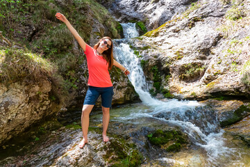 Hiker woman next to idyllic river Foelzbach, Hochschwab mountains, Styria, Austria. Hiking trail in alpine forest. Remote Austrian Alps in summer. Sense of escapism, reflection. Connect with nature