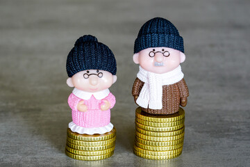 Figures of old retired people on different piles of money coins, concept of income inequality