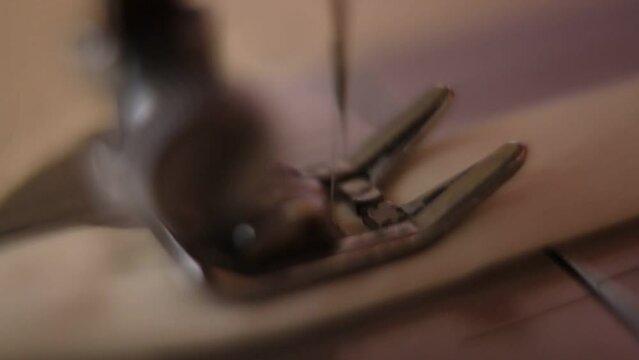 A lateral macro shot from an old sewing machine working on a piece of cloth in southeast brazil