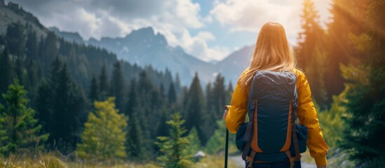 Serene young woman with a backpack enjoying a peaceful walk through a lush forest landscape with vibrant greenery - obrazy, fototapety, plakaty