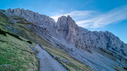 Panoramic view of majestic mountain cliff Schartenspitze in untamed Hochschwab mountain region, Styria, Austria. Scenic hiking trail in shadows in remote Austrian Alps. Wanderlust in alpine summer