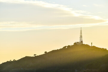 Telecommunications tower on top of a mountain during sunset