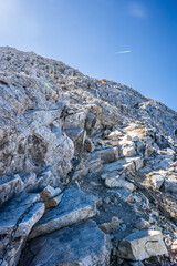 Mt. Vihren rocky slope between its summit and Kazana shelter against blue sky. "Karst rib" with a chain attached to the rocks for safe climbing. Pirin mountains in Bulgaria.