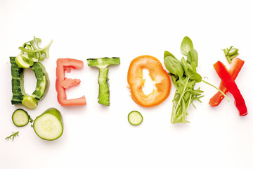 The detox lettering consists of different vegetables and greens on a white background