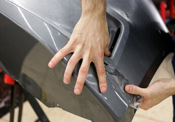 Close up of paint protection film installation on front bumper of modern luxury car. PPF is...