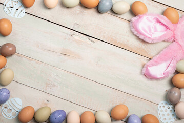 Easter holiday background with multi colored eggs on a whitewashed plank background.