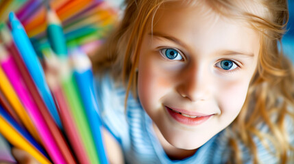 Fototapeta na wymiar Happy little girl with colored pencils